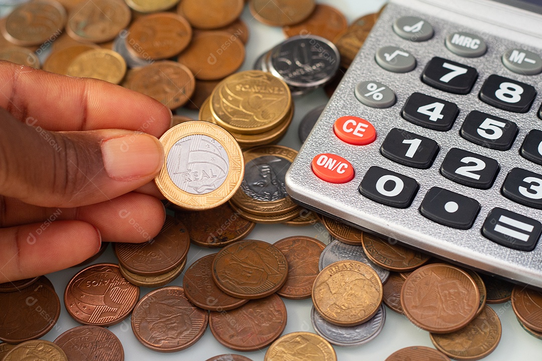 Calculadora cercada por moeda real brasileira
