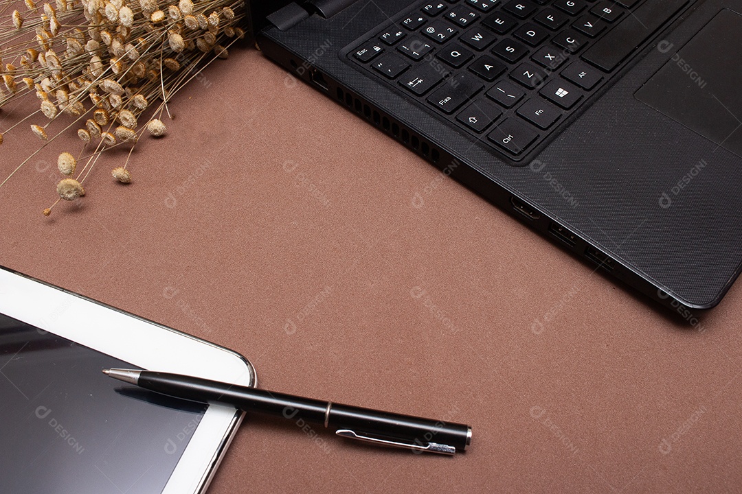 tablet e laptop na mesa de fundo marrom - escritório
