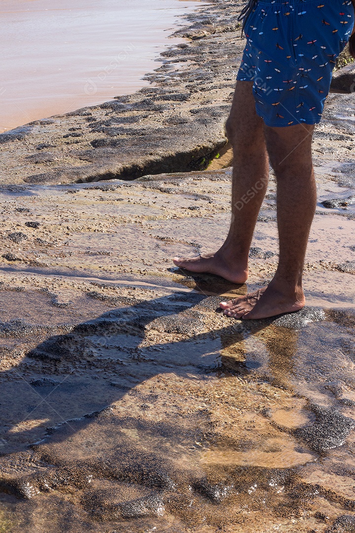 vista dos pés de um homem na praia