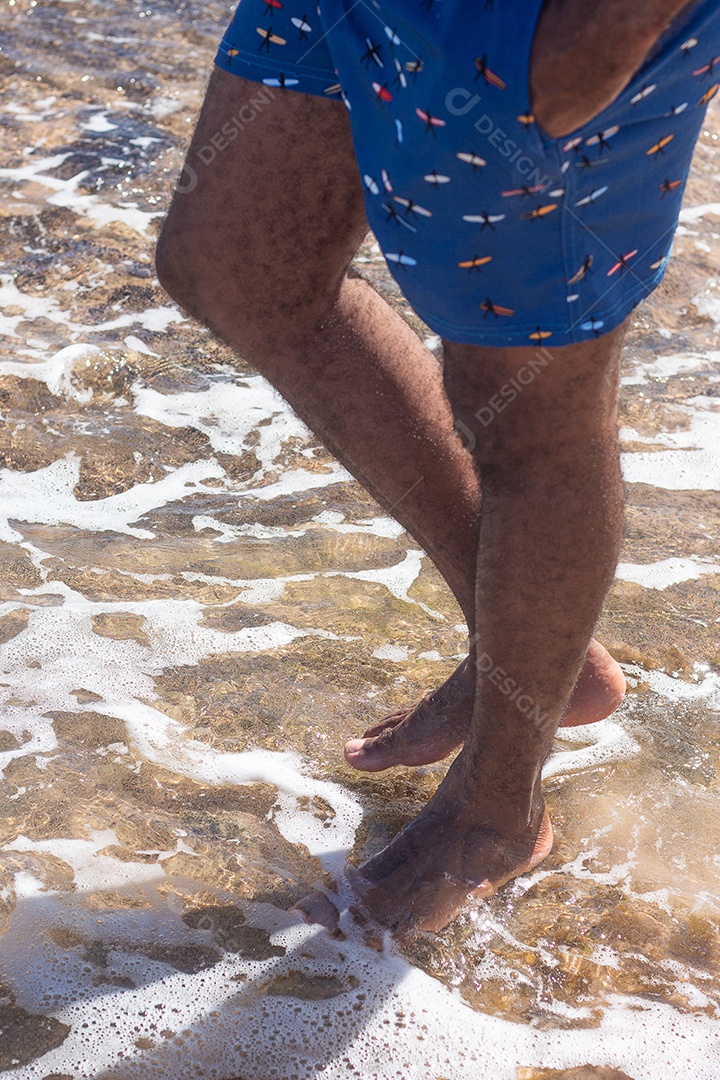 vista dos pés de um homem na praia