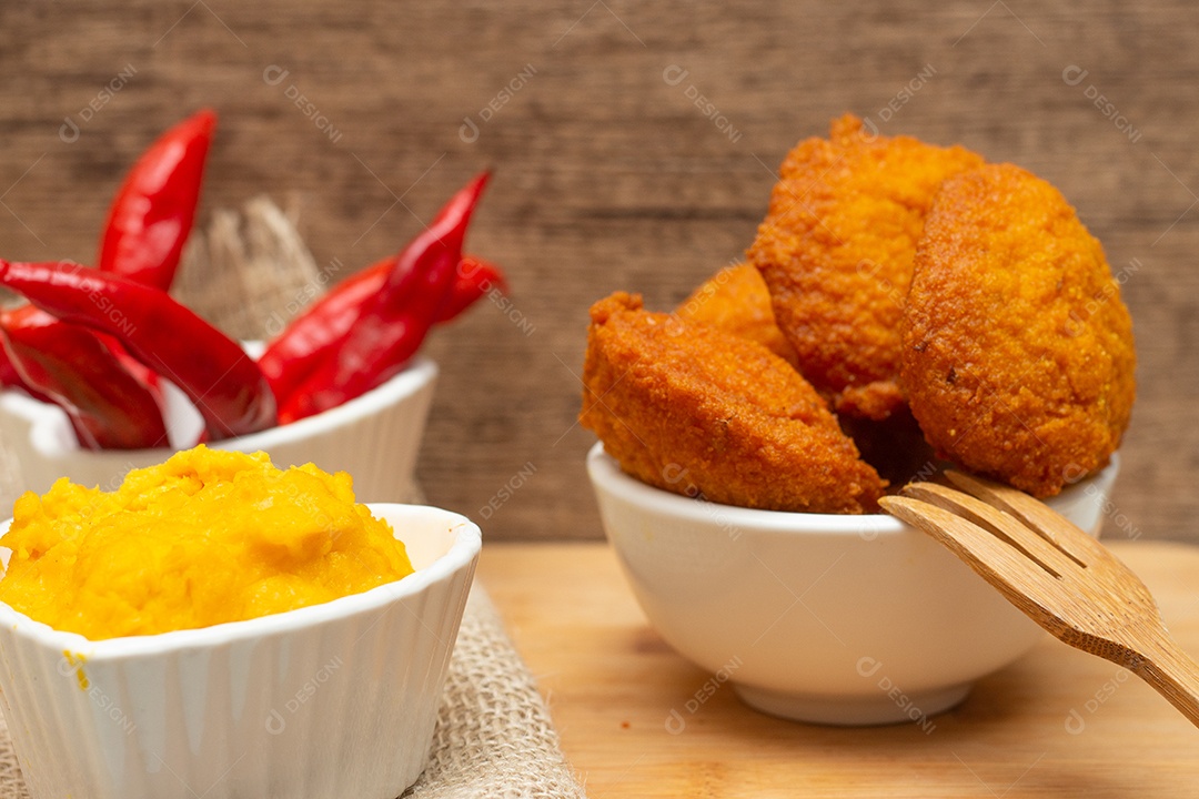 Comida típica da Bahia chamada acarajé cercada de pimenta vermelha