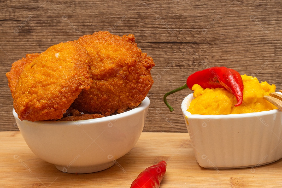 Comida típica da Bahia chamada acarajé cercada de pimenta vermelha