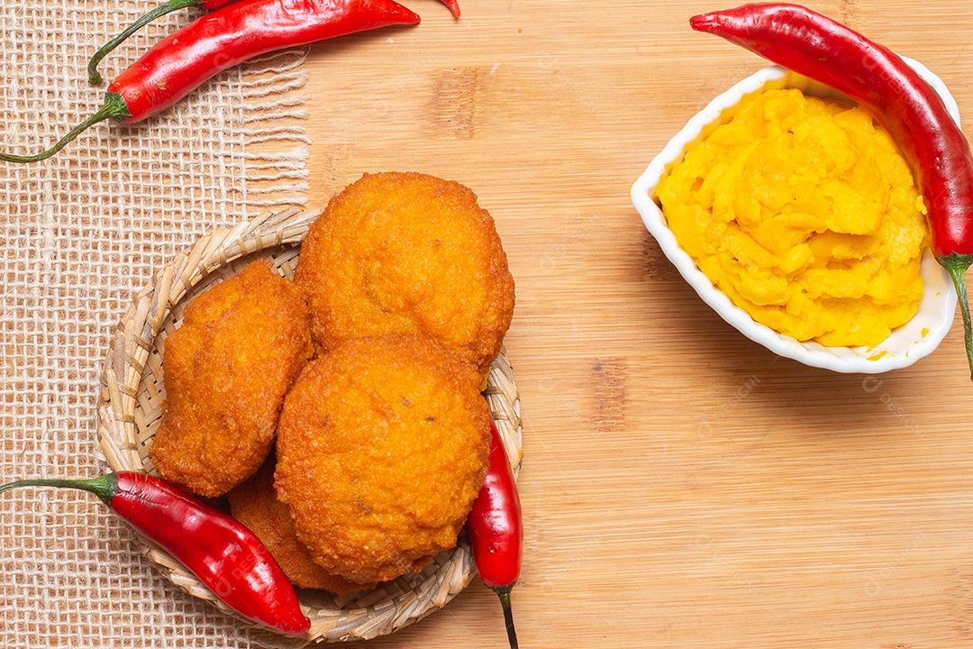 Comida típica da Bahia chamada acarajé cercada de pimenta vermelha