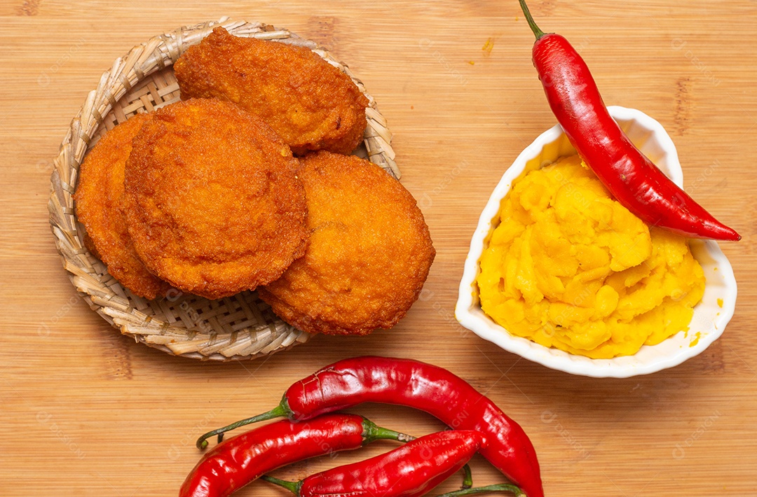 Comida típica da Bahia chamada acarajé cercada de pimenta vermelha