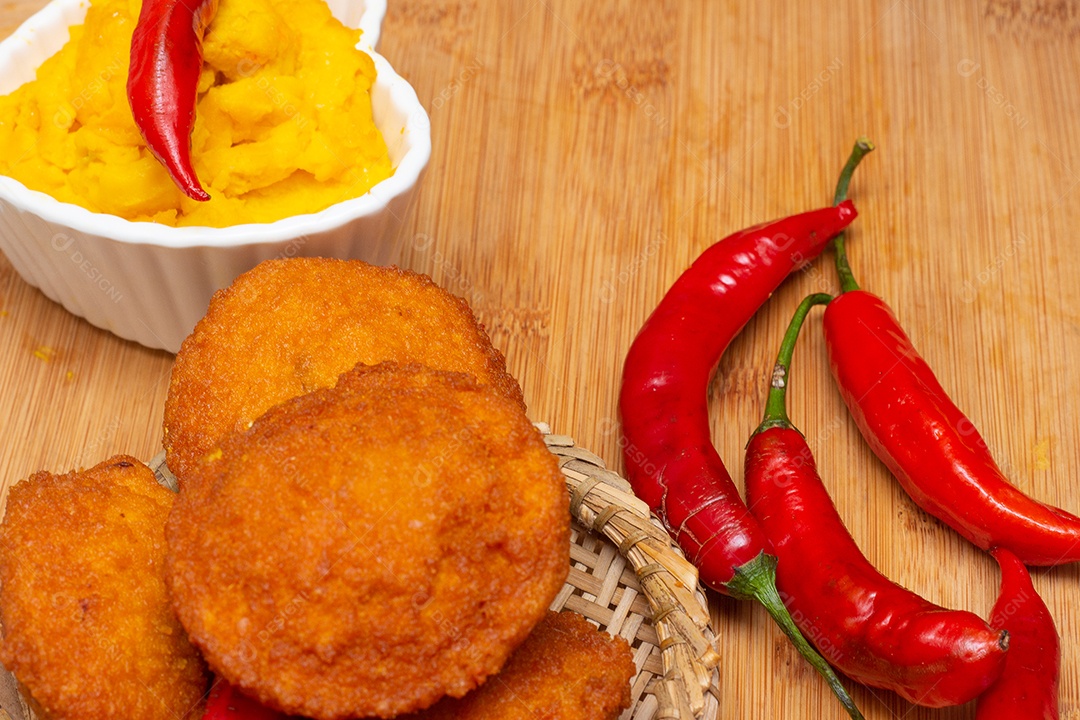 Comida típica da Bahia chamada acarajé cercada de pimenta vermelha