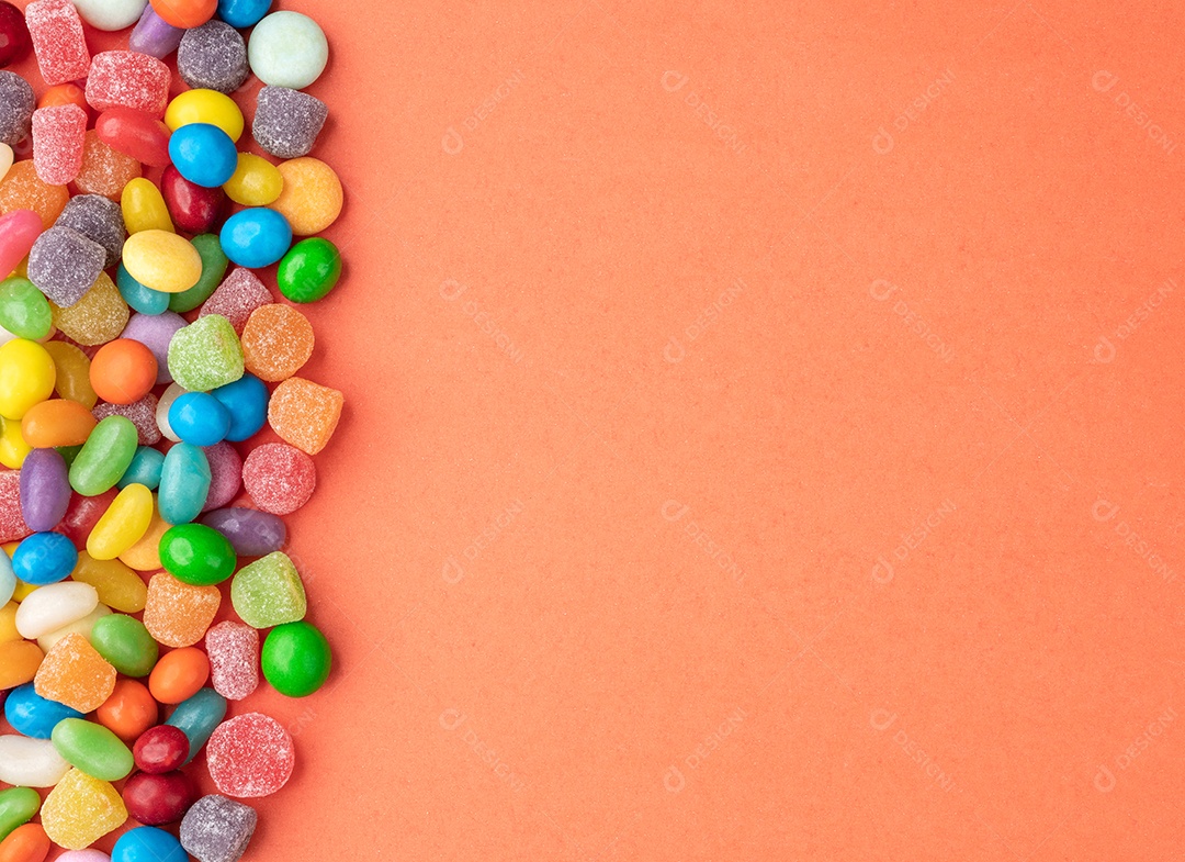 Doces coloridos sobre fundo laranja