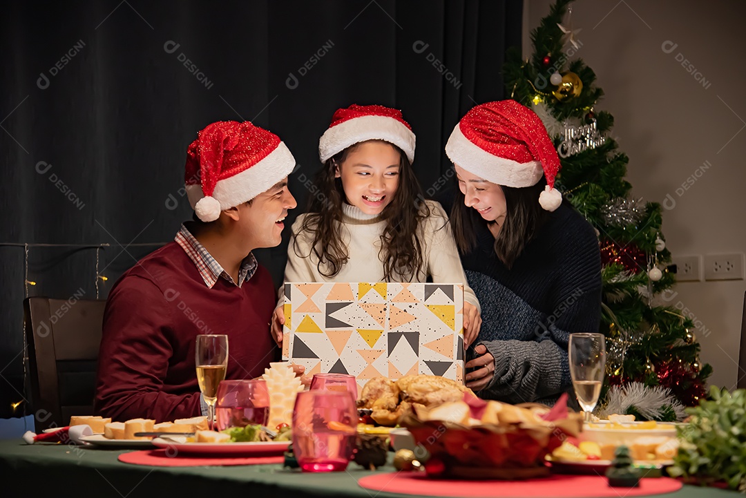 Pai e mãe dão presentes às crianças no dia de Natal.