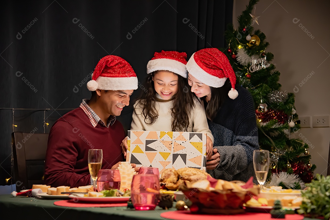 Pai e mãe dão presentes às crianças no dia de Natal.