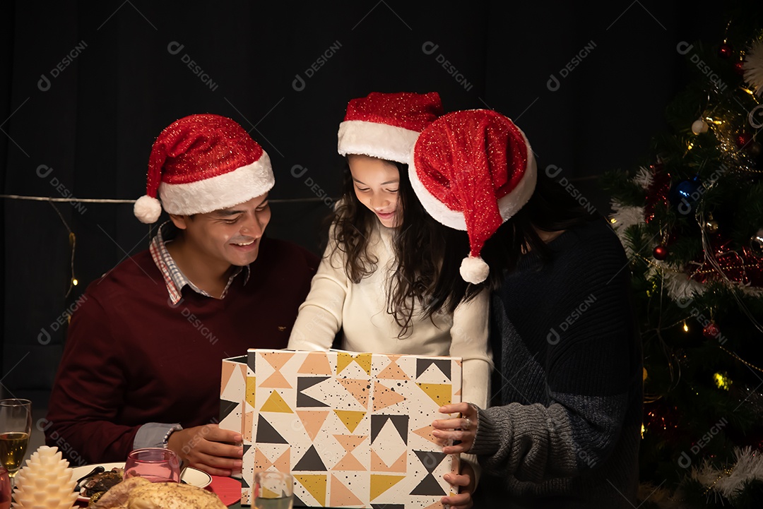 Pai e mãe dão presentes às crianças no dia de Natal.