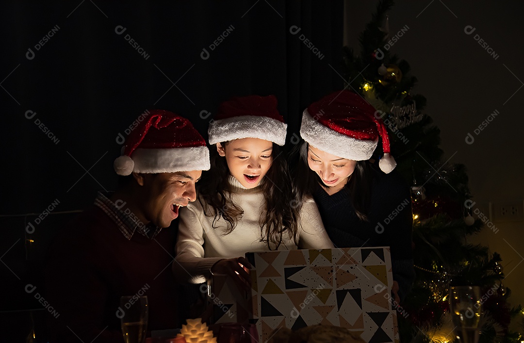 Pai e mãe dão presentes às crianças no dia de Natal.