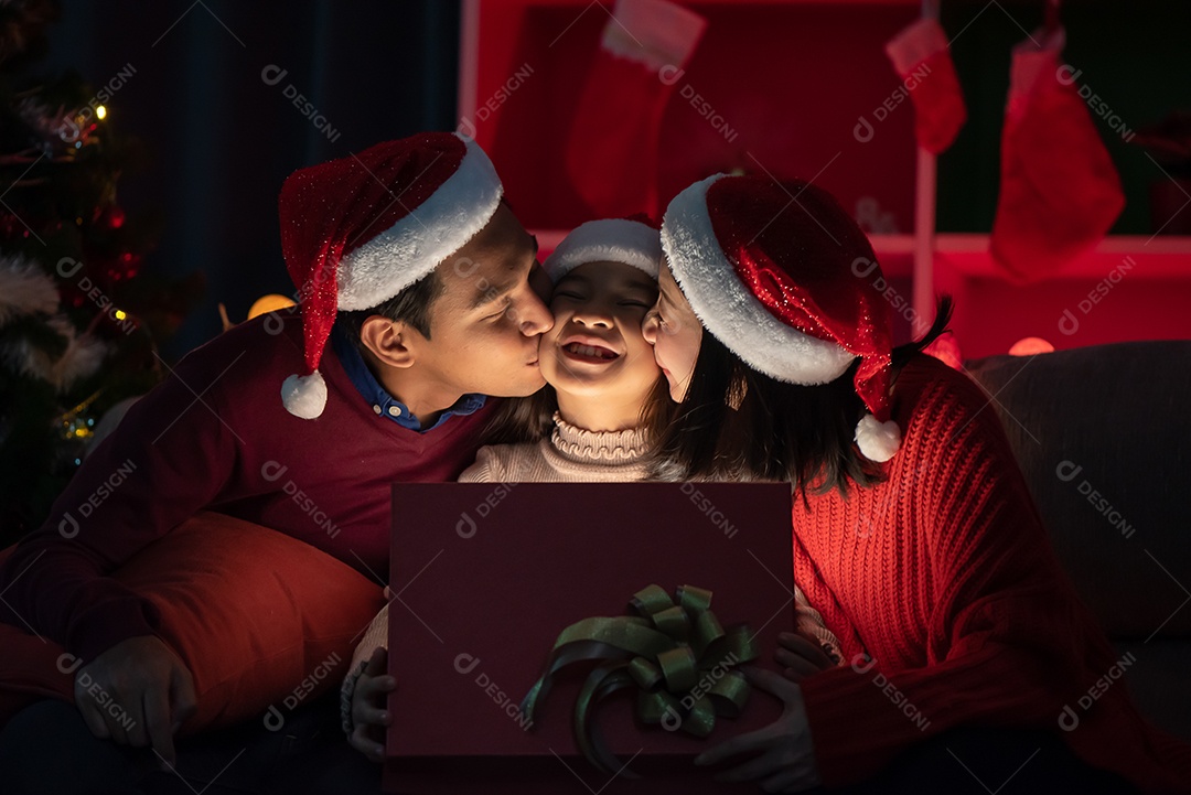 Pai e mãe dando presentes para as filhas nas celebrações do dia de Natal.