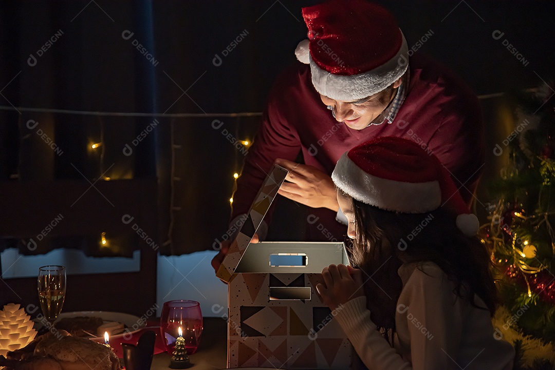 Pai abre presentes para filha no dia de Natal.