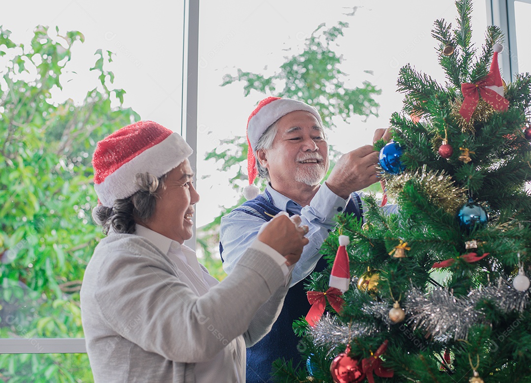 Casal idosos decorando a árvore de natal