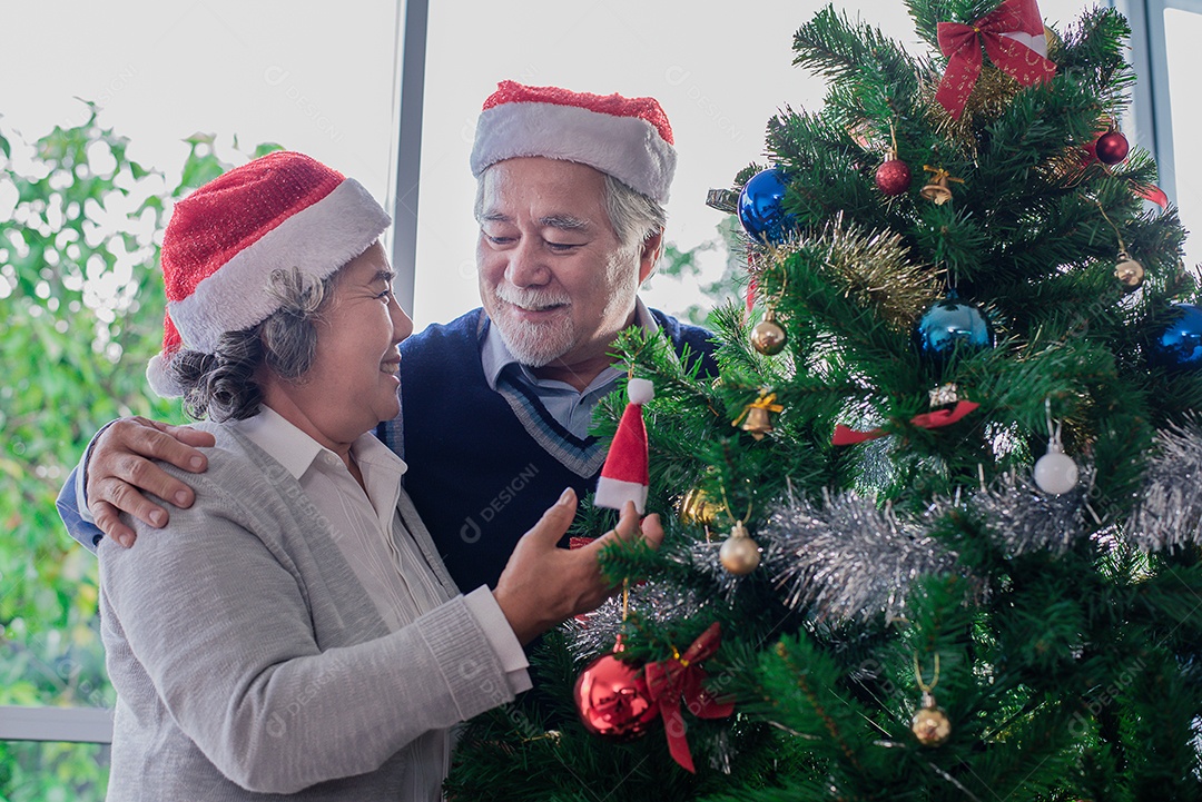 Casal idosos decorando a árvore de natal, foco seletivo