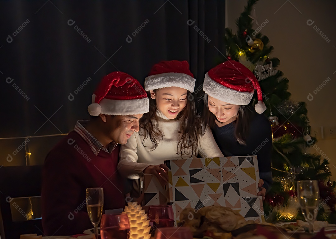 Surpresa, pais e filhas abrem uma caixa de presente no dia de Natal