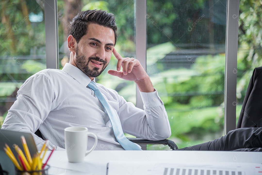 Empresário sentado contemplando no escritório moderno