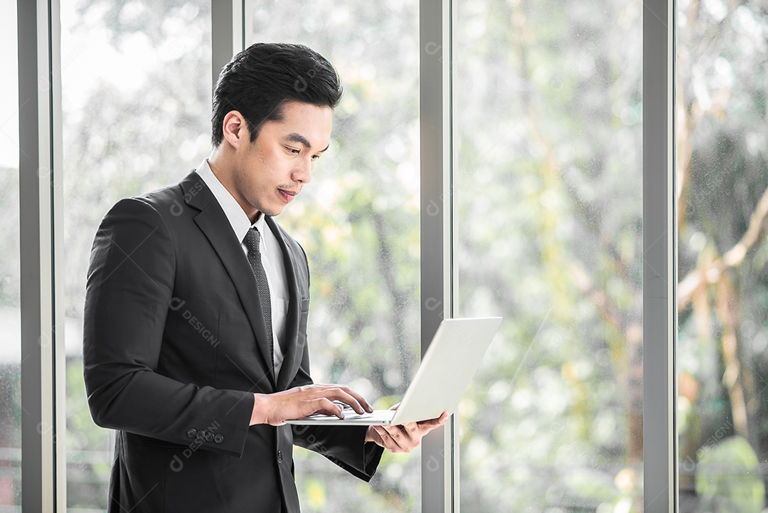 Empresário de pé confiante enquanto usa tablet