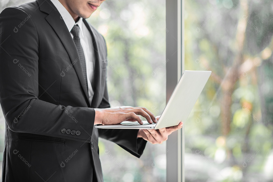 Empresário de pé confiante enquanto usa tablet