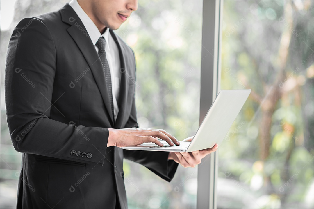 Empresário de pé confiante enquanto usa tablet