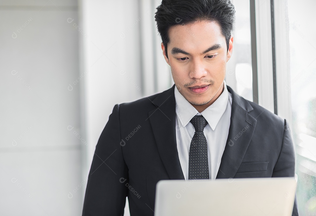 Empresário de pé confiante enquanto usa tablet