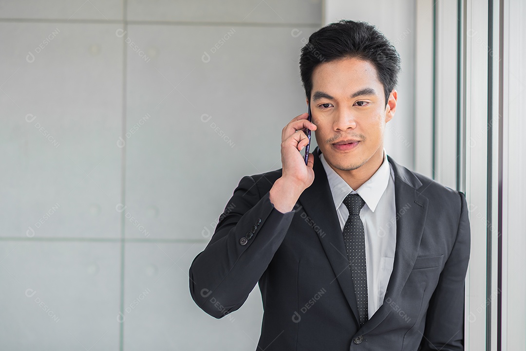 Homem de negócios que está contemplando ao usar o telefone celular