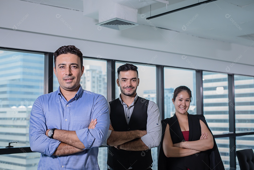 Três empresários com braços cruzados em pé no escritório moderno