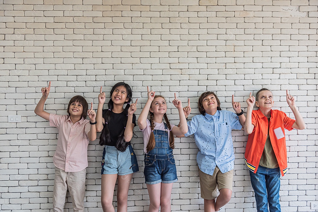 Estudantes de escolas internacionais levantam as mãos e olham para cima