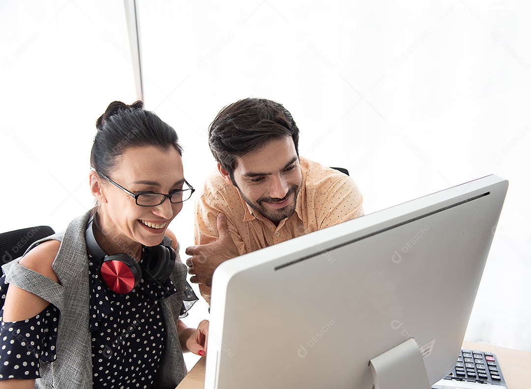 Filho e mãe olham para o computador e sorriem