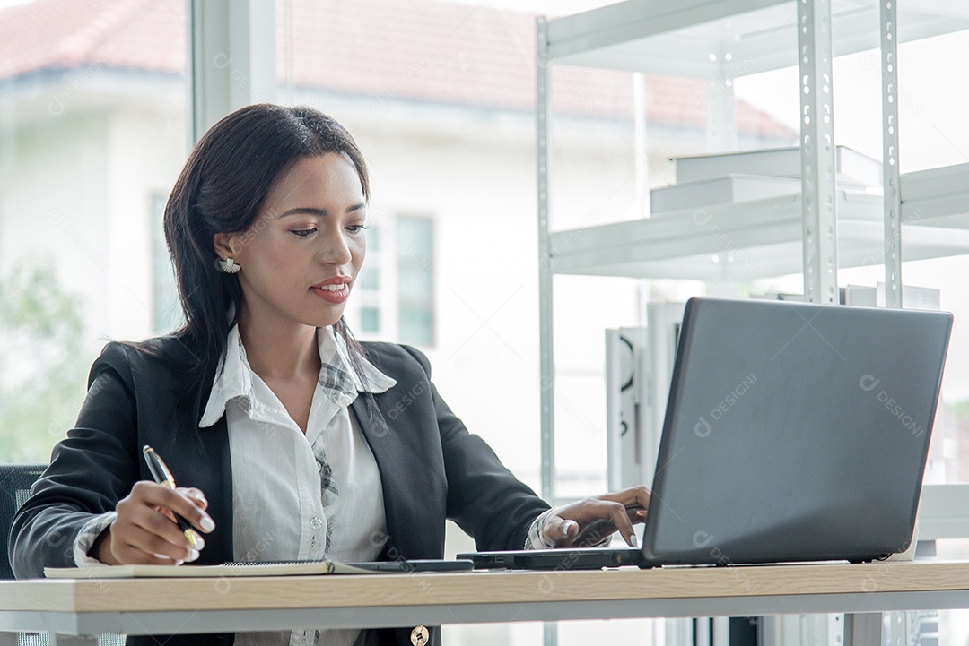 Mulher de negócios africana trabalhando no escritório usando computador e escrito