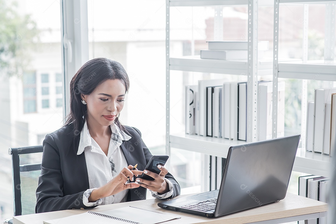 Mulher de negócios africana trabalhando no escritório usando a retenção do computador