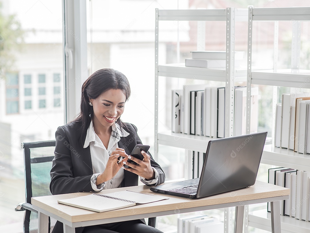 Mulher de negócios africana trabalhando no escritório usando a retenção do computador