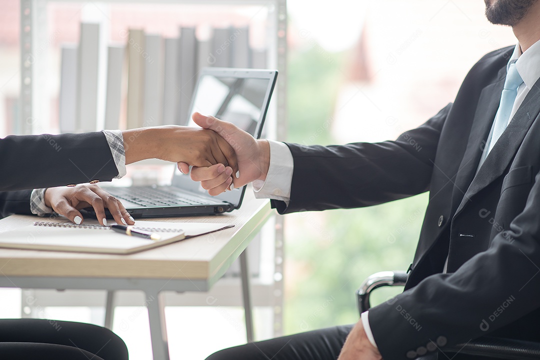 Mulheres de negócios africanas apertam as mãos de um homem de negócios concordando