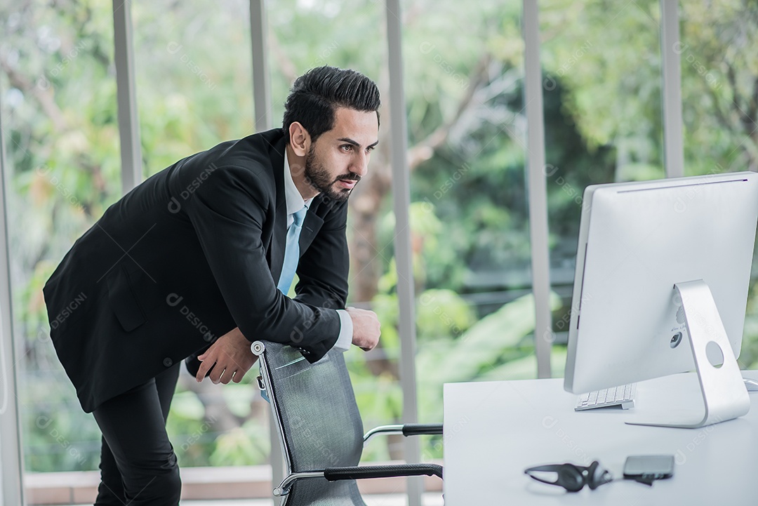 Homem de negócios vestindo um terno olhar computador no escritório