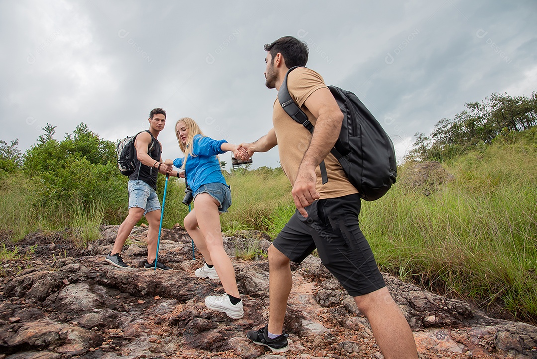 Grupo de amigos de mãos dadas na montanha durante caminhada