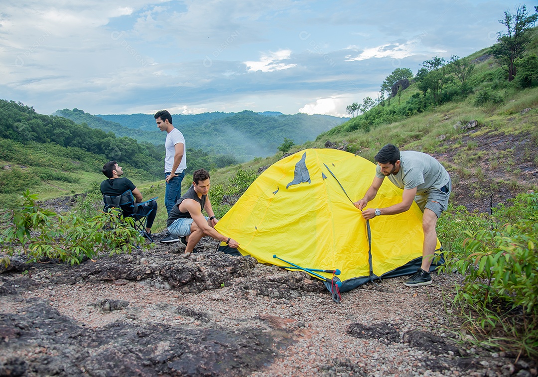 Grupo de amigos do sexo masculino estão armando tendas