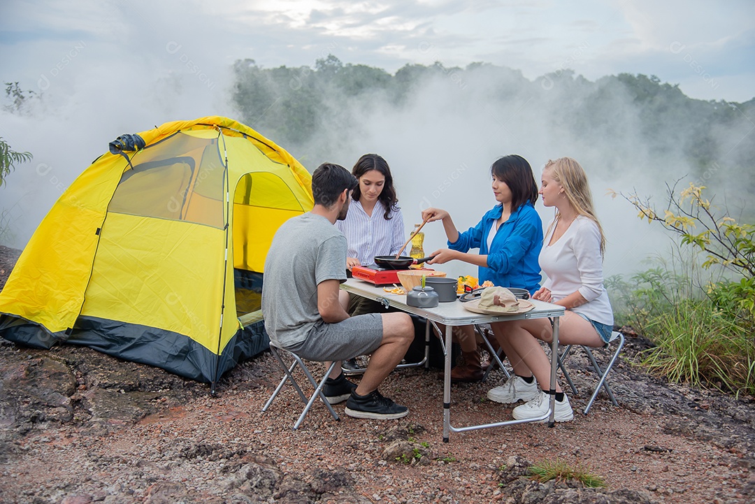 Grupo de amigos homens e mulheres preparam uma mesa de piquenique