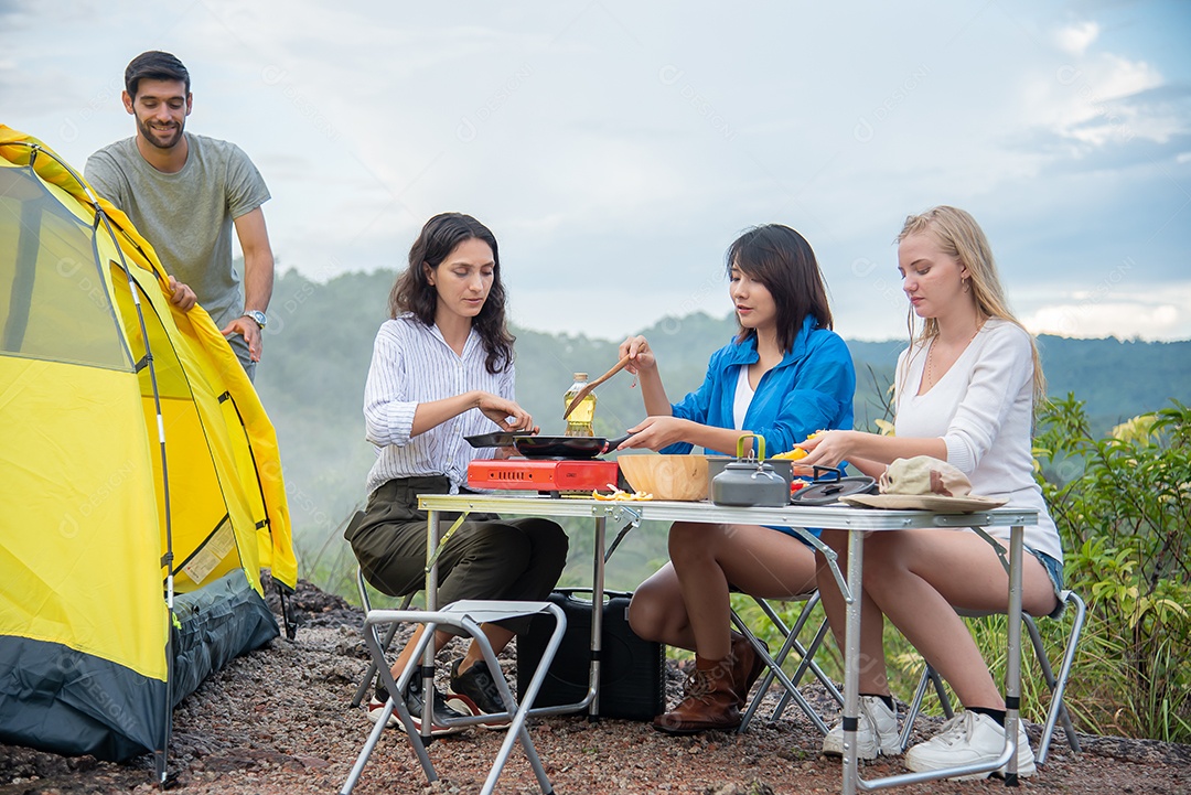 Grupo de amigos homens e mulheres preparam uma mesa de piquenique