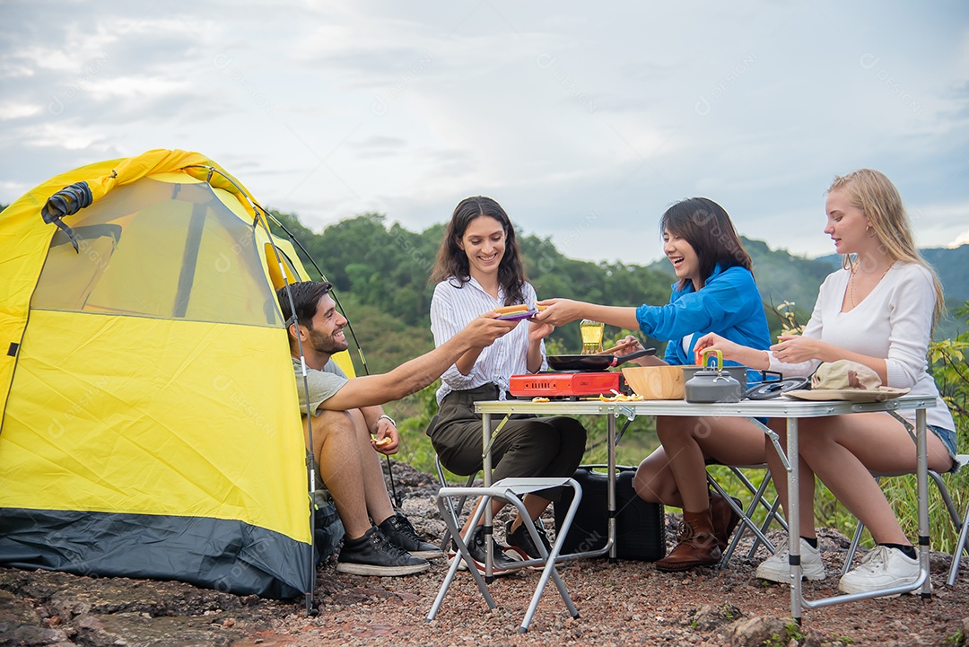 Grupo de amigos homens e mulheres preparam uma mesa de piquenique