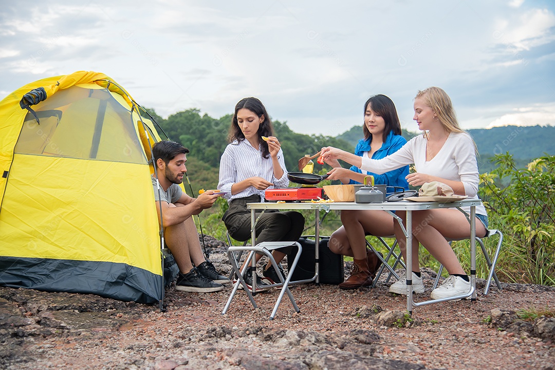 Grupo de amigos homens e mulheres preparam uma mesa de piquenique