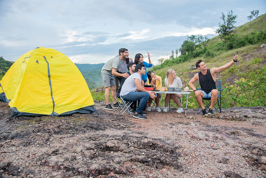 Grupo de amigos homens e mulheres preparam uma mesa de piquenique