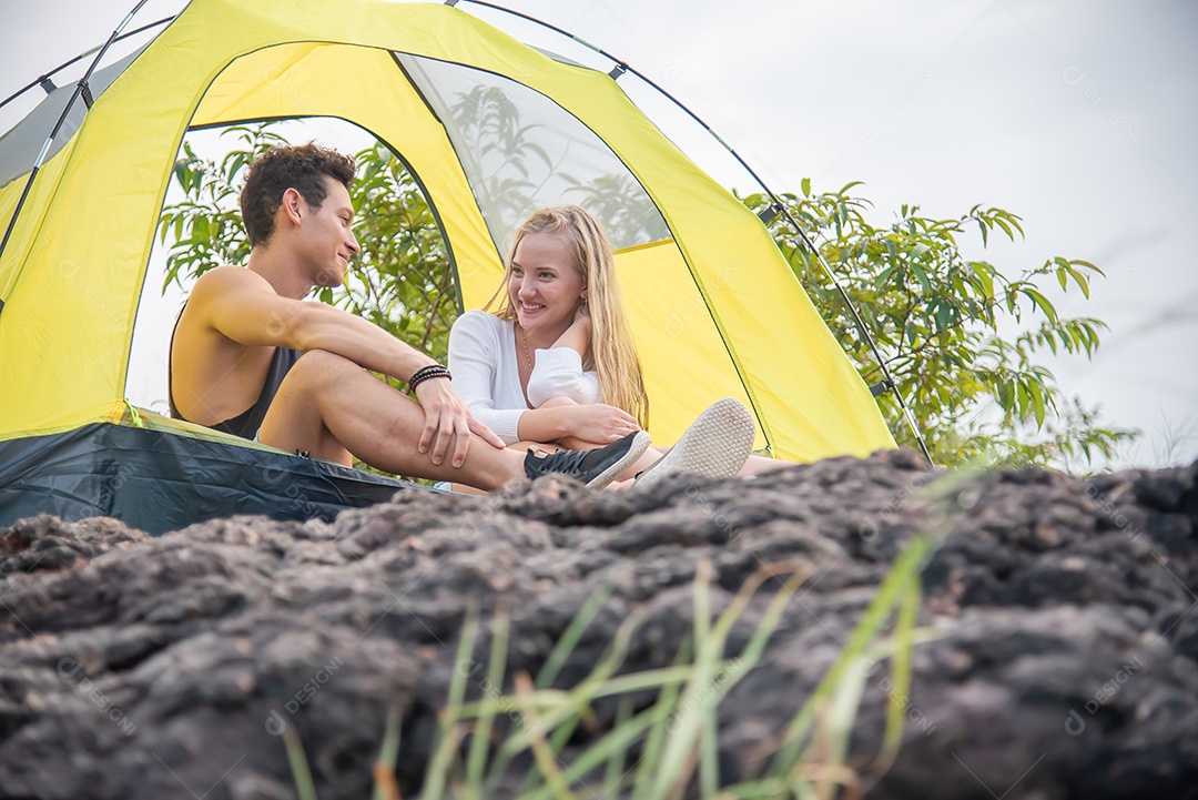 Homem e namorada sentam na barraca conversando entre a bela montanha