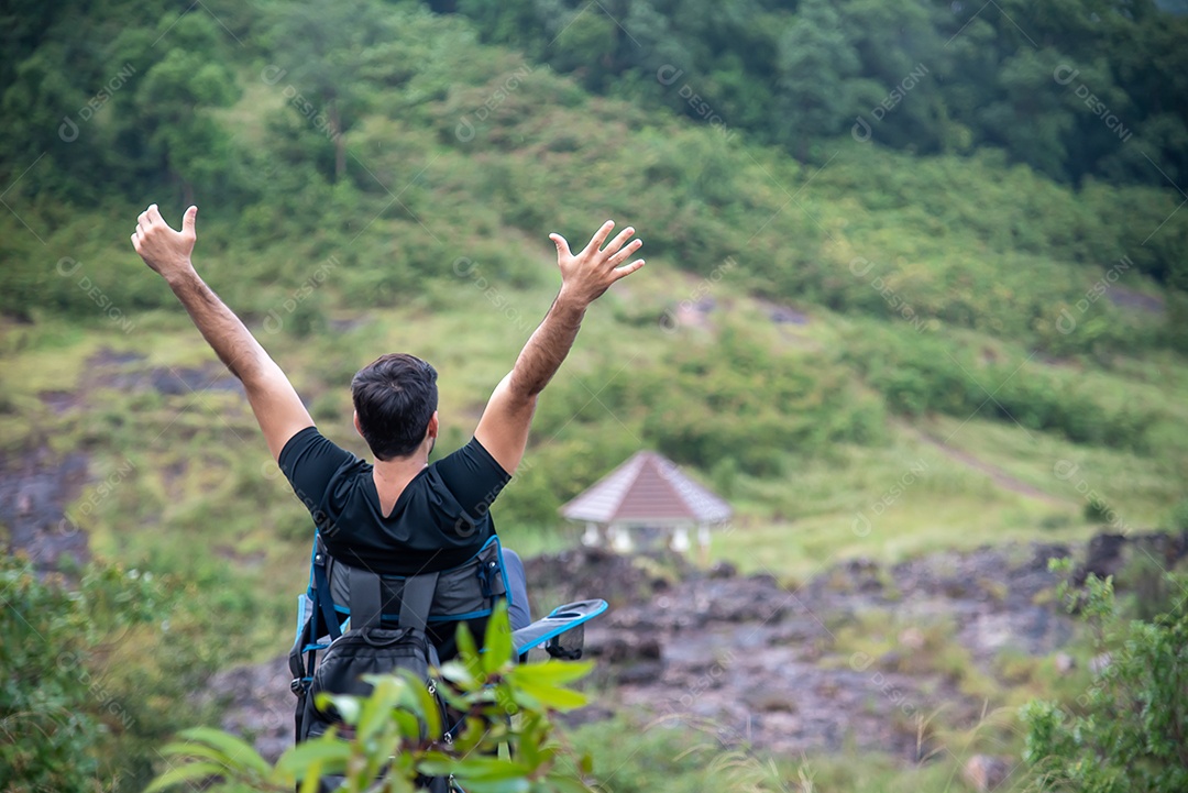 Homem se senta em uma cadeira relaxando entre as belas montanhas