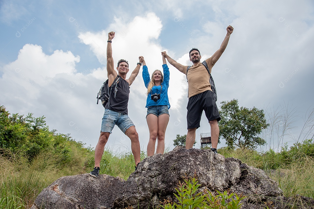 Dois homens bonitos e uma mulher levantando as mãos em pé