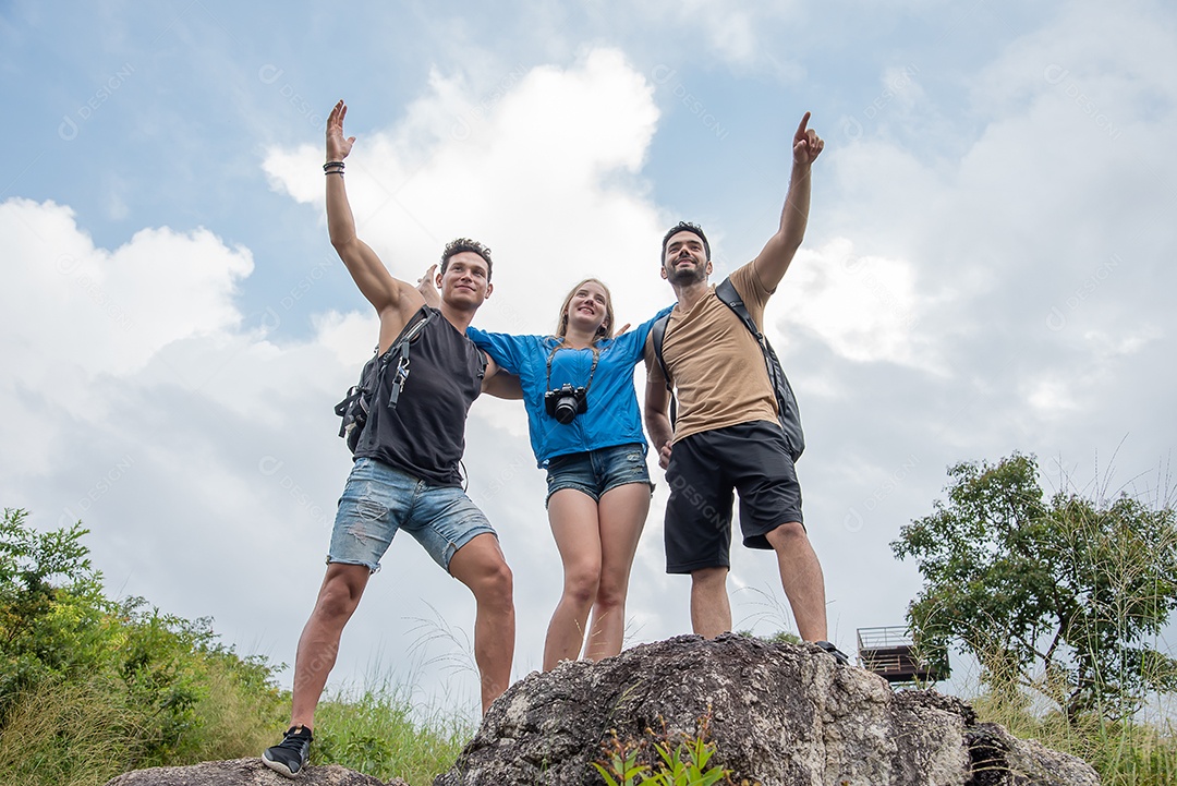 Dois homens bonitos levantando as mãos e mulher sorrindo em pé