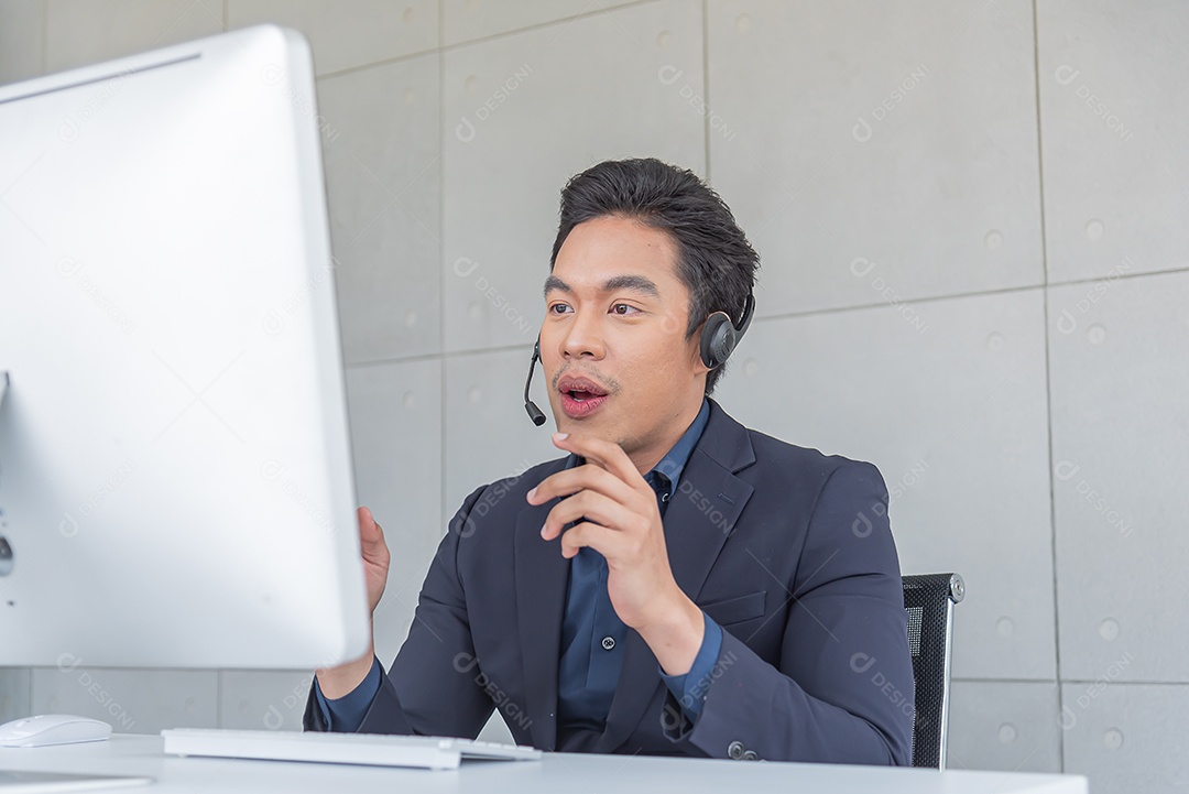 Jovem asiático usa terno trabalhando recebendo chamada usar fone de ouvido
