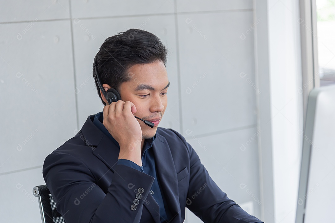Jovem asiático usa terno trabalhando recebendo chamada usar fone de ouvido