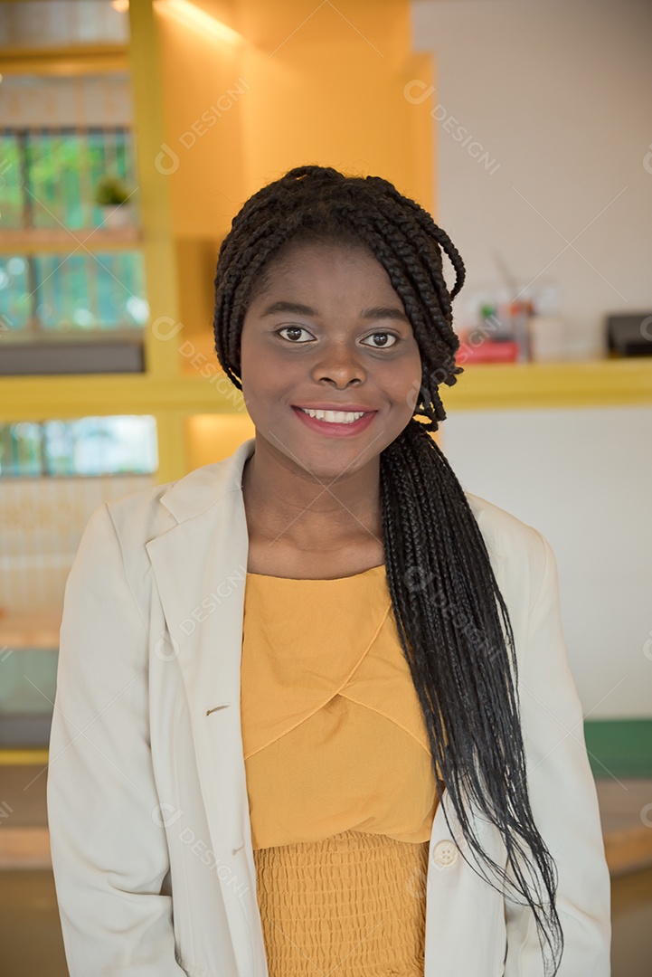 Retrato de uma mulher africana na biblioteca ou espaço de trabalho e sorriso