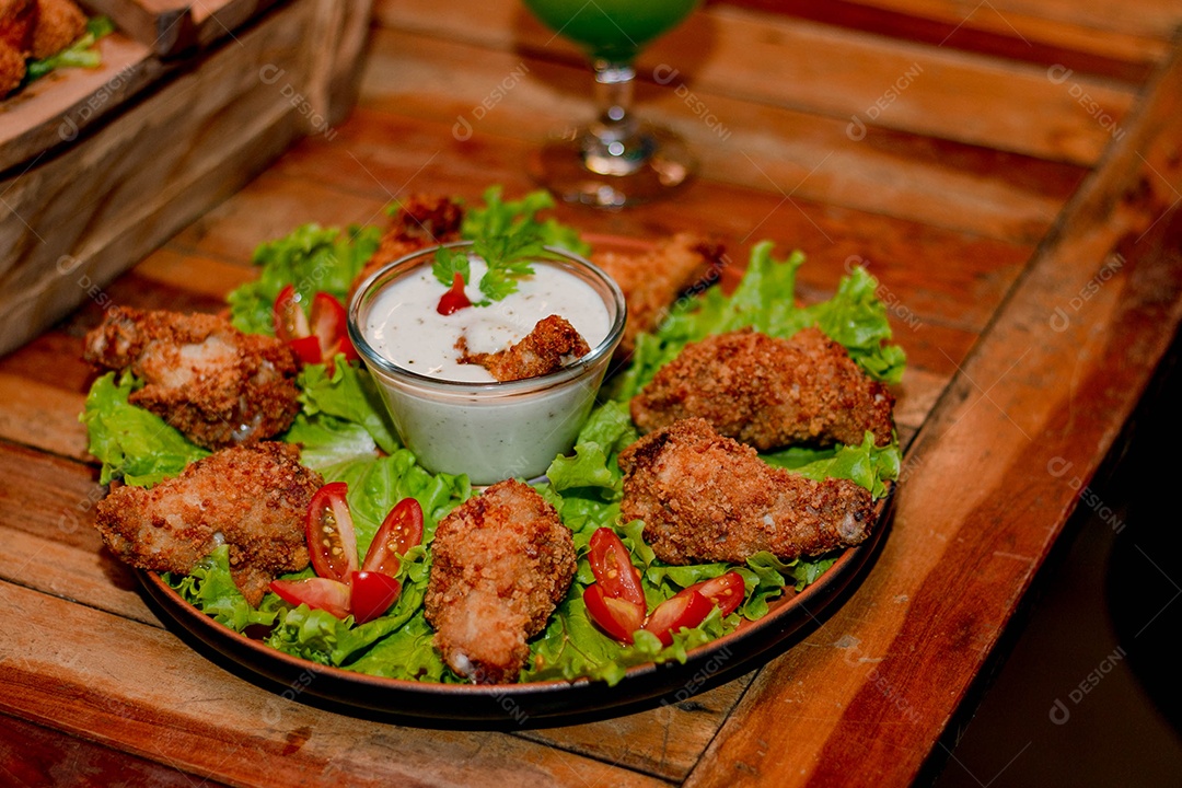 Frango a passarinho servido em bandeja com salada de alface e tomate