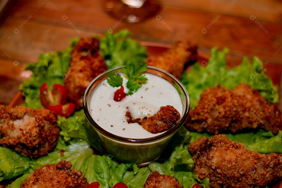 Frango a passarinho servido em bandeja com salada de alface e tomate