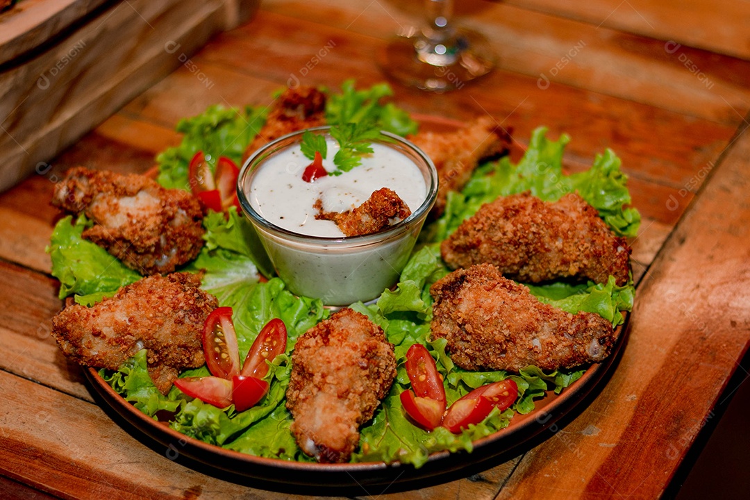 Frango a passarinho servido em bandeja com salada de alface e tomate